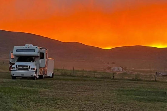 An RV at sunset in an open field