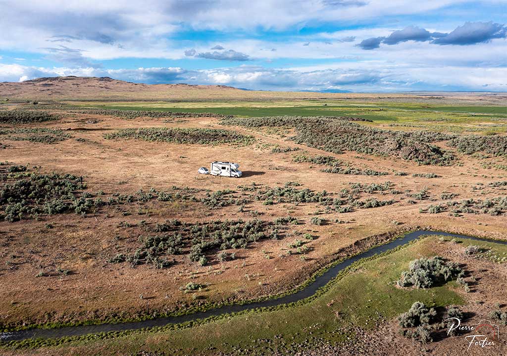 RV in a desert field by a stream